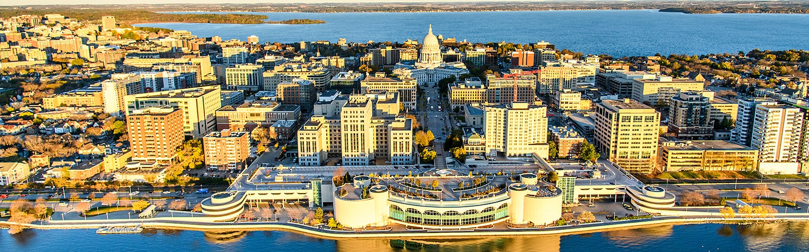 Aerial view of downtown Madison and the isthmus with the Wisconsin State Capitol Building in the center.