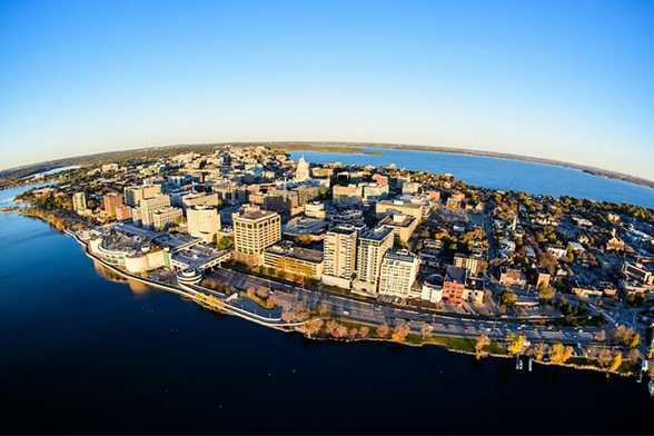 Aerial view of downtown Madison set between the isthmus on a clear day with blue skies.
