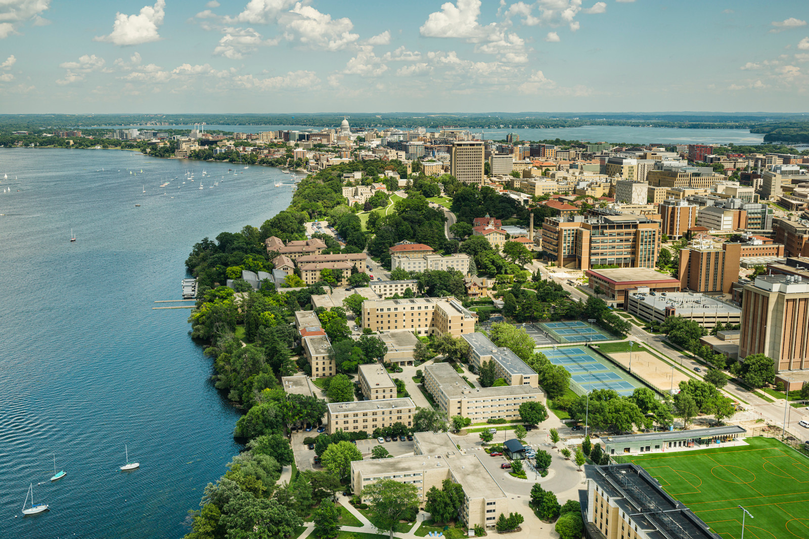 Aerial view of campus buildings and downtown Madison set between the isthmus.