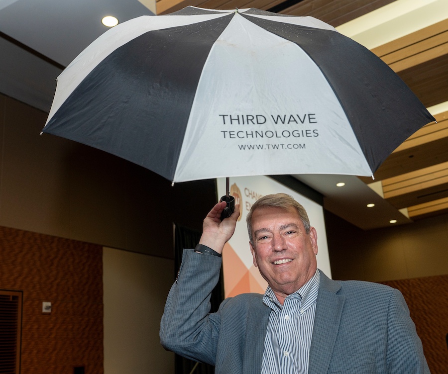 Guest at the awards reception holds up an open umbrella with the text 